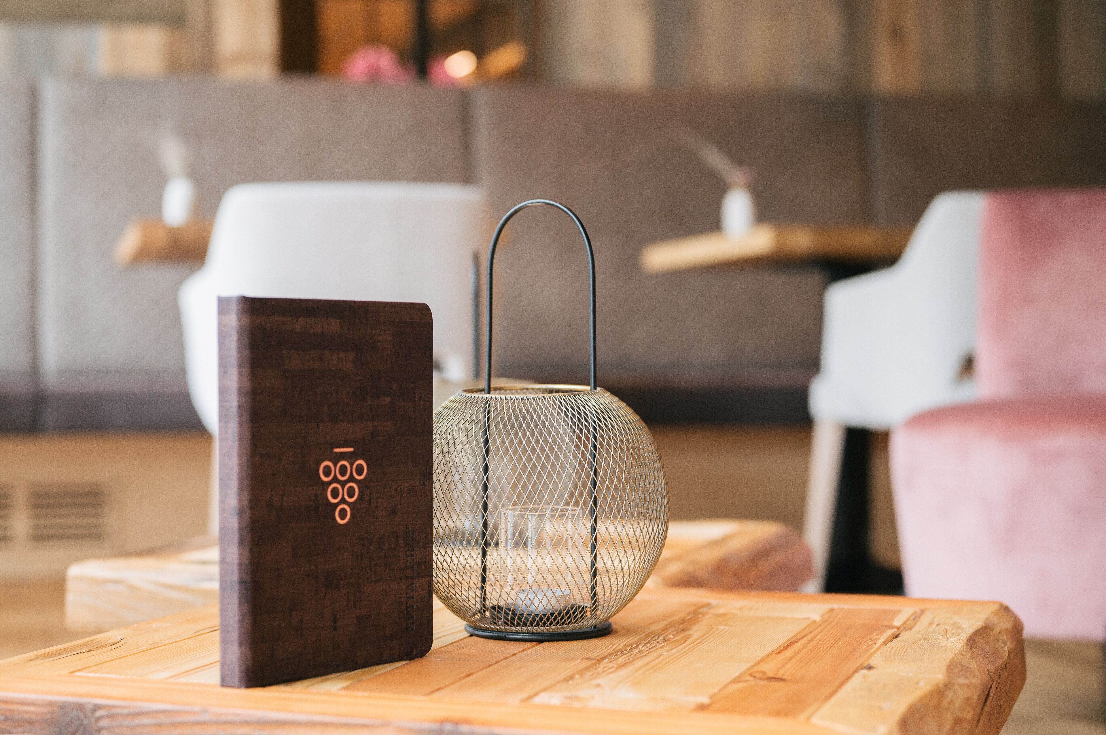 A wooden table with a metal lamp and a book.