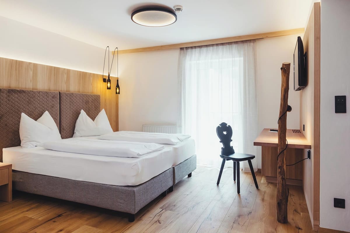 Une chambre d’hôtel moderne, dotée d’un grand lit, d’un bureau et d’une télévision.