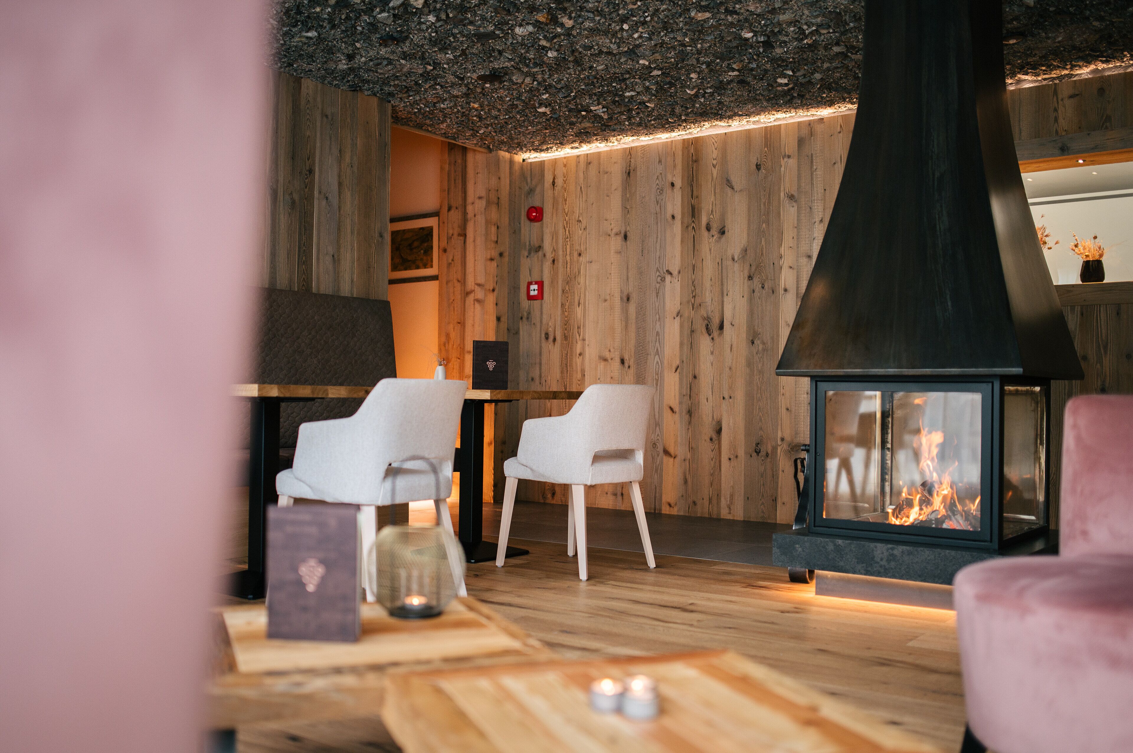 Una habitación acogedora con chimenea, paredes de madera y muebles modernos.