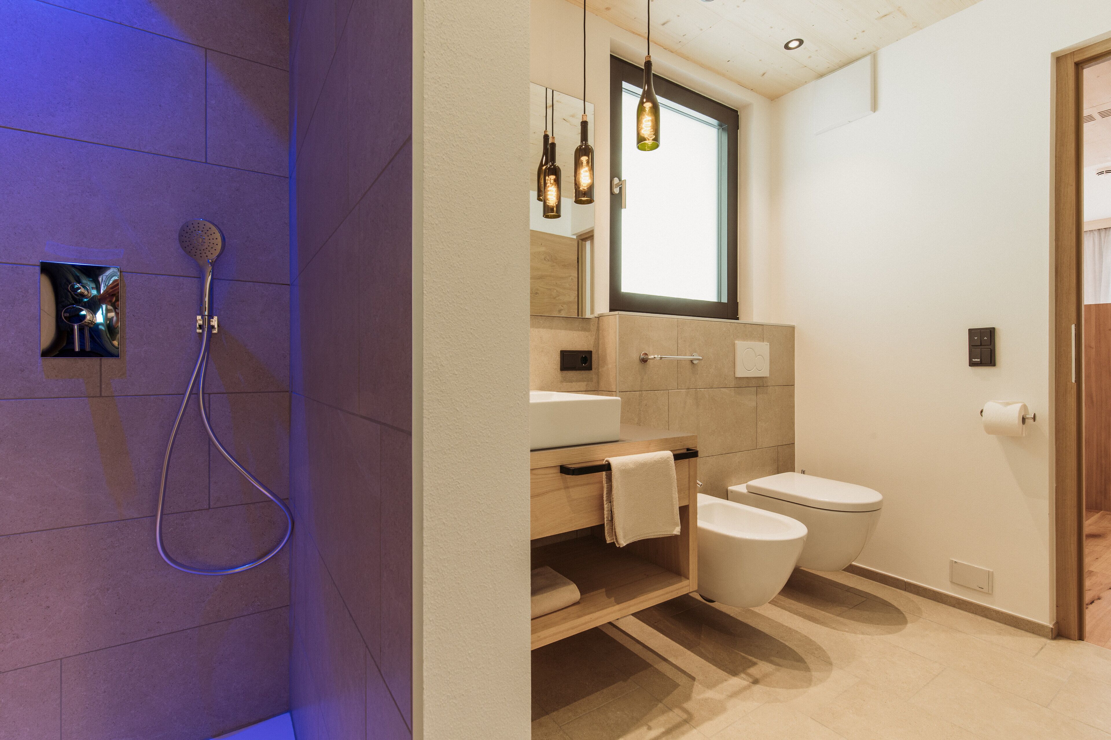 A modern bathroom with a shower, toilet, and sink.