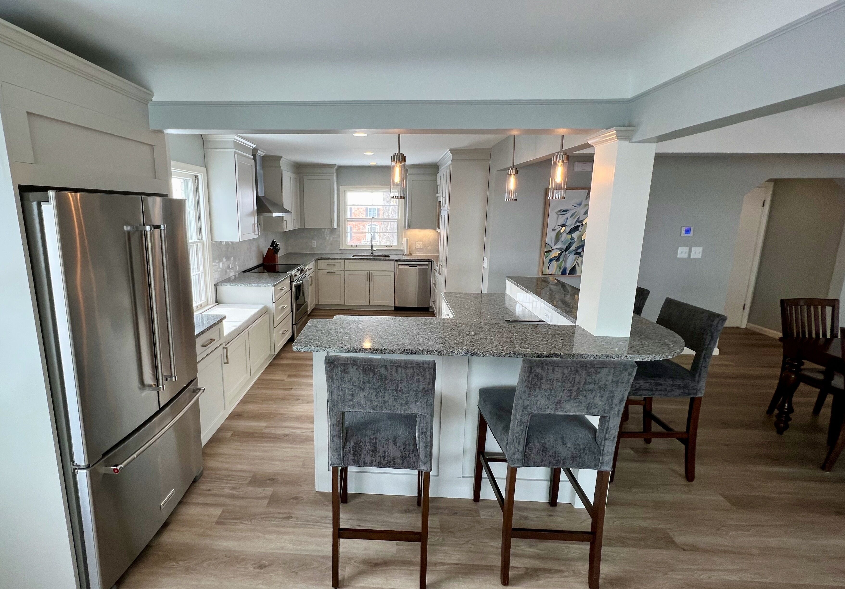 Una cocina moderna con una isla central, electrodomésticos de acero inoxidable y una zona de comedor con taburetes de bar.