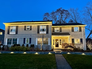 A two-story house with a well-maintained lawn and a pathway leading to the front door. - Grosse Pointe Windmill Pointe 3BR Upper Flat – Spacious, Airy and Spotless (Grosse Pointe Park)