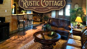 L’intérieur d’un chalet rustique, avec un bar en bois, un canapé en cuir et une cheminée.
