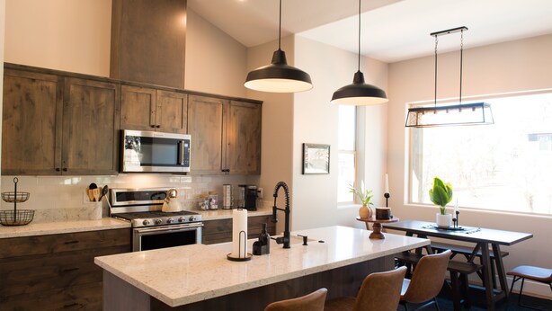 A modern kitchen with wooden cabinets, stainless steel appliances, and a central island with bar stools. - Custom 4bd Mountain & Golf Retreat, Sleeps 8,
A/C, Close to All Key Attractions (Williams)