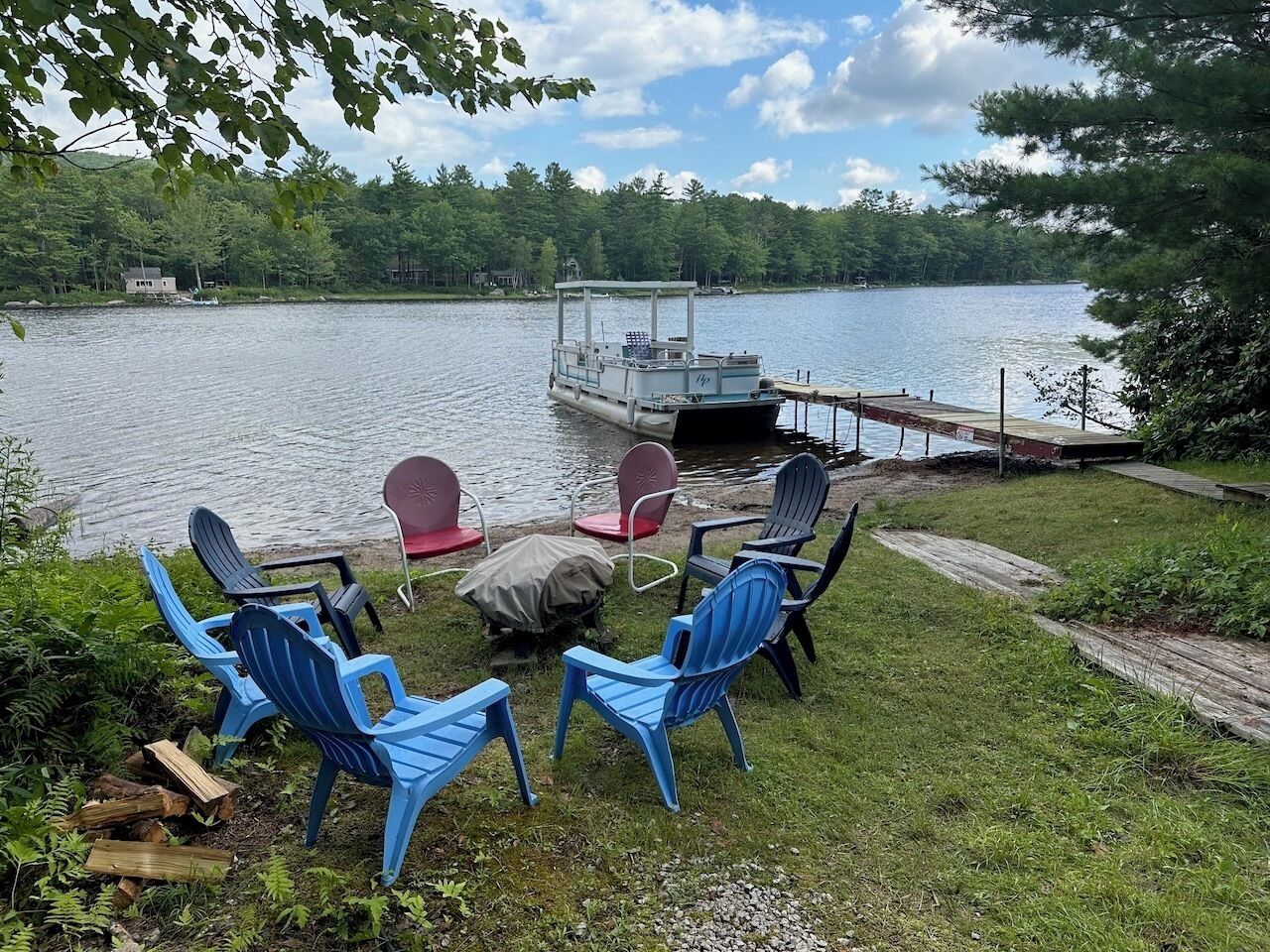 A lakeside seating area with chairs and a covered dock.