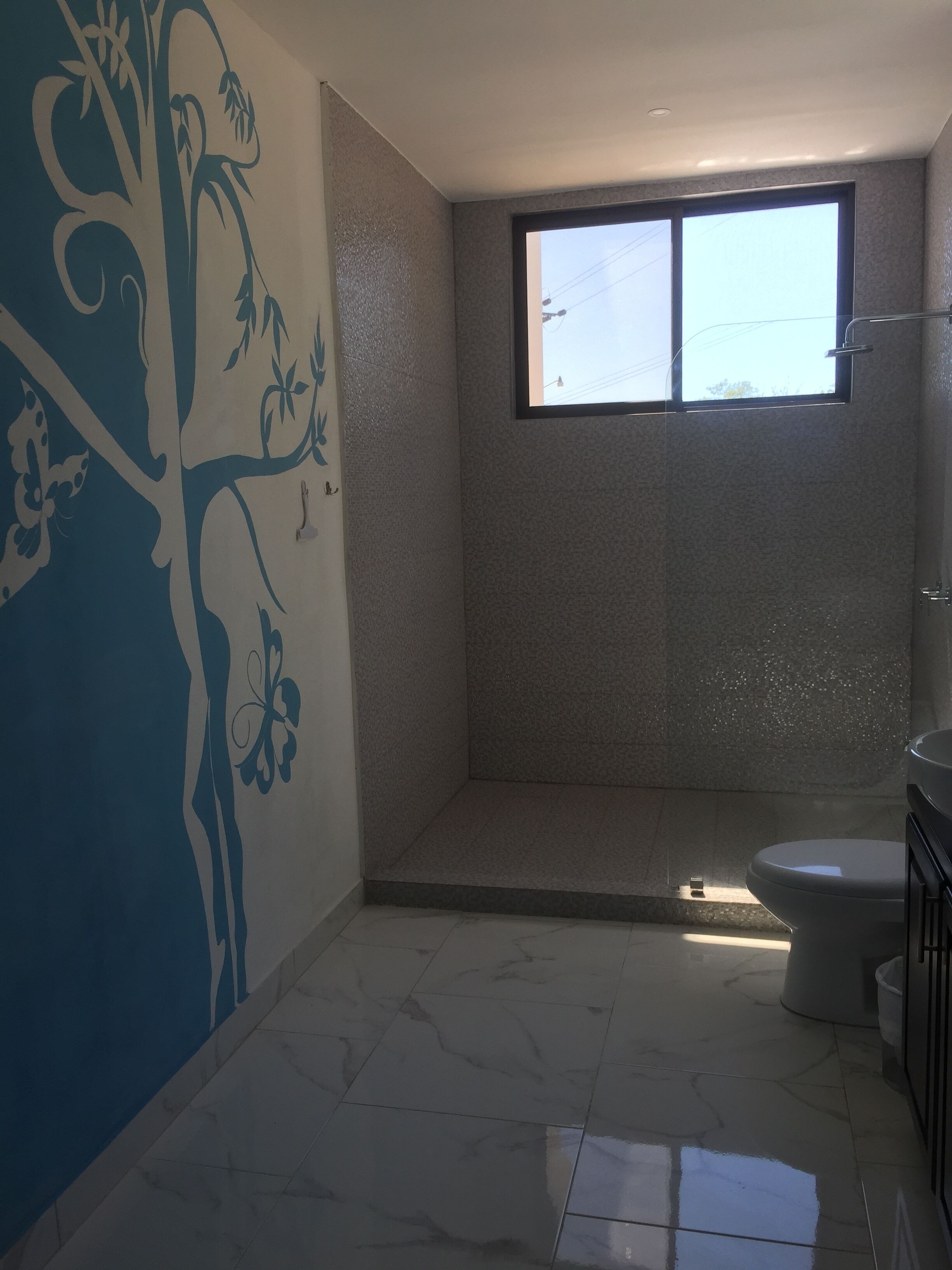 A bathroom with a shower, toilet, and sink.