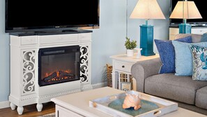 Smart TV, chimenea, libros y monitor de computadora 
