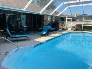 An outdoor swimming pool with lounge chairs and a covered patio area. - Quiet Family Friendly Saltwater Pool Home, Near Beach (Navarre)