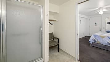 A bedroom with a bed, a chair, and a door leading to another room.