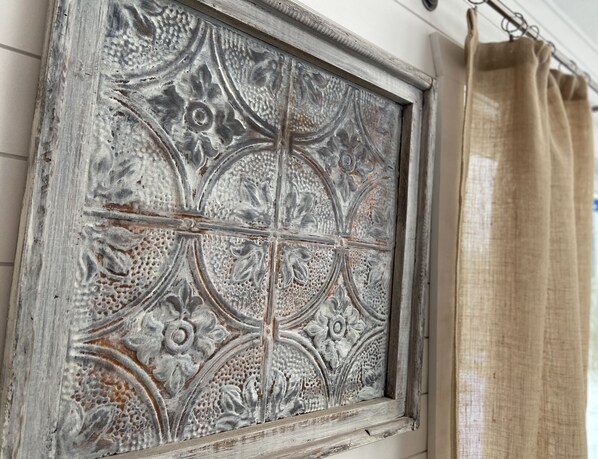 Een raam met ingewikkelde bloem- en geometrische patronen, in een rustieke houten lijst.