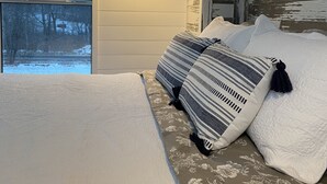 Une chambre à coucher avec un lit, une fenêtre et une lampe.