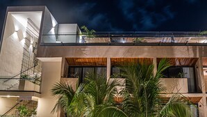 A modern multi-story building with a balcony, large windows, and indoor plants. - Moonshine Tulum Hotel  (Tulum)