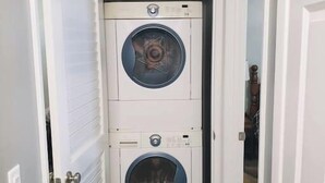 Une buanderie équipée de deux machines à laver à chargement frontal superposées.