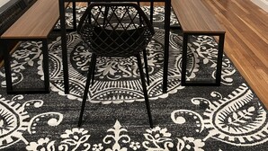 A modern kitchen with a built-in oven, a dining area with a wooden table and black chairs, and a patterned rug. - Newly renovated1 Bedroom 1 Bath in the Heart of Downtown Ellsworth.  (Ellsworth)