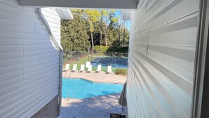 A covered outdoor area leading to a swimming pool with a fence and lounge chairs. -  FALL in love with this 1 BD/1 BA at Island Retreat. Plenty of dates available. (St. Simons Island)