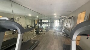 A gym with treadmills, exercise machines, and a mirrored wall. -  FALL in love with this 1 BD/1 BA at Island Retreat. Plenty of dates available. (St. Simons Island)