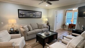 A living room with a sofa, armchairs, a coffee table, and a ceiling fan. -  FALL in love with this 1 BD/1 BA at Island Retreat. Plenty of dates available. (St. Simons Island)