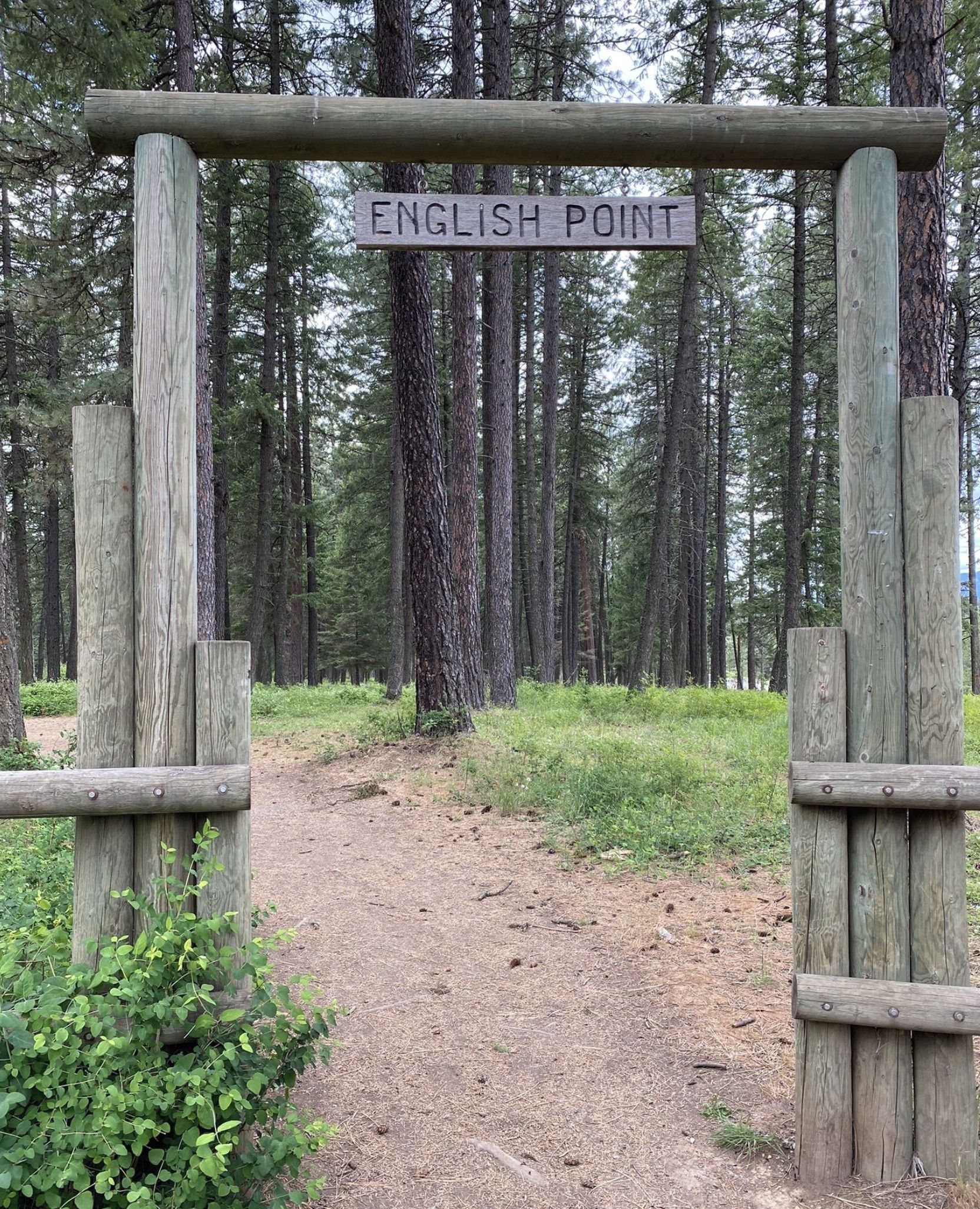 Une pancarte en bois indiquant « ENGLISH POINT » à l’entrée d’une zone boisée.