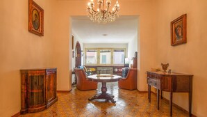 A spacious hallway with a chandelier, a round table, and two armchairs. - 3 bedroom pet friendly home in Piombino (Piombino)