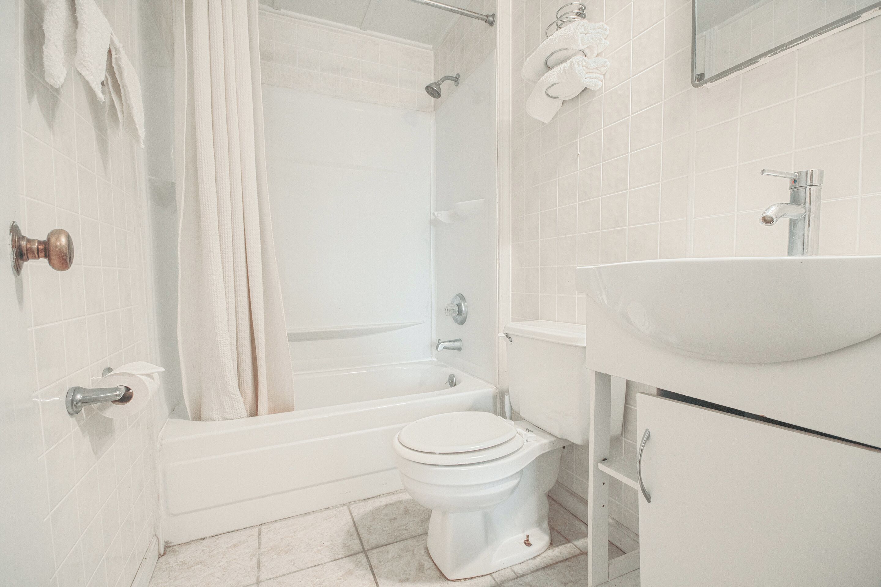 A bathroom with a bathtub, toilet, and sink.