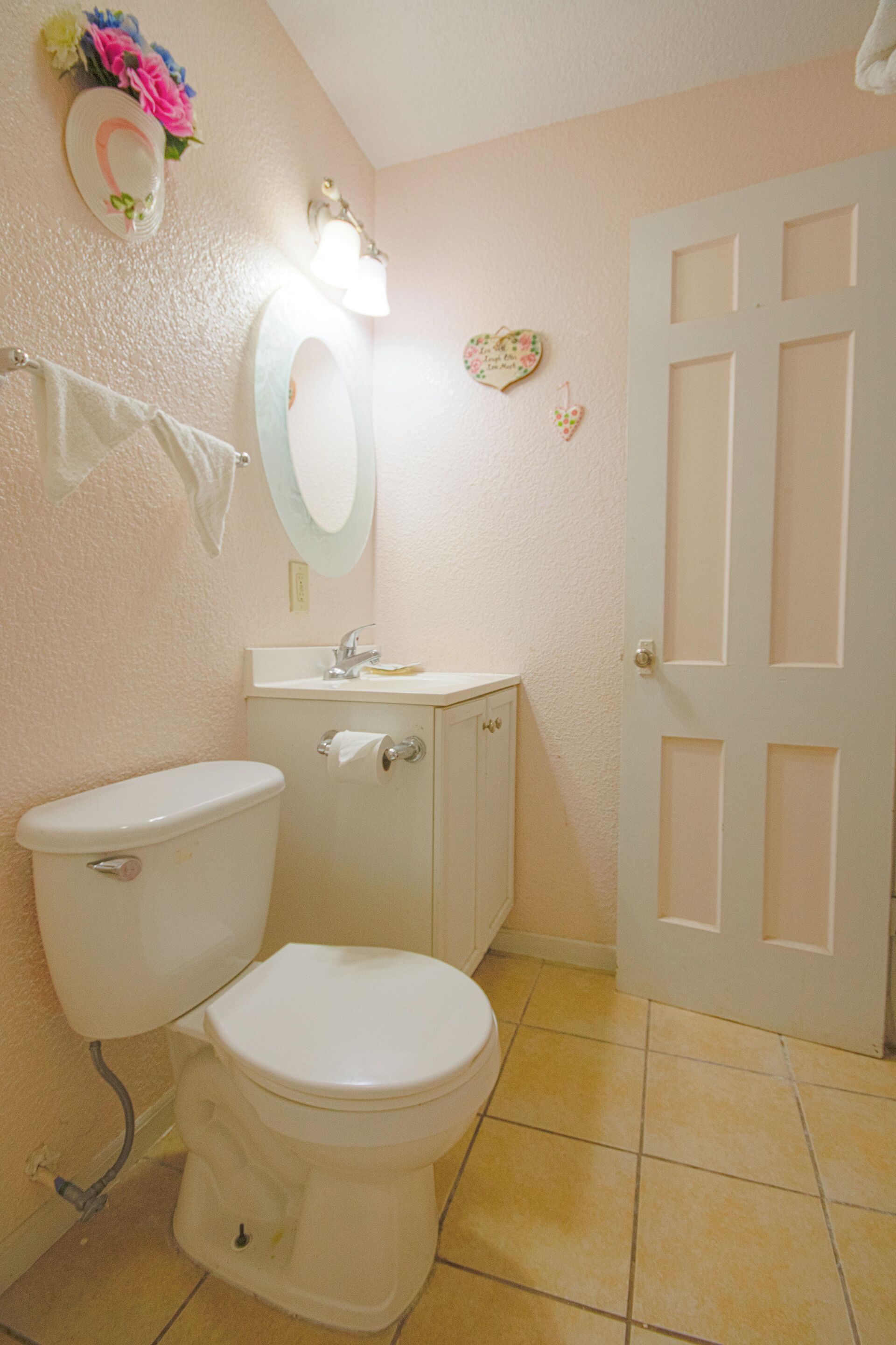 A bathroom with a toilet, sink, and mirror.