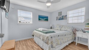 A bedroom with a bed, two windows, a ceiling fan, a desk, and a chair. - Guest Favorite- walk to the beach! (Salvo)