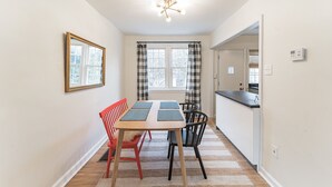 A dining area with a table, chairs, and a window with curtains. - Sunny & Stylish Manayunk Cottage w/ Private Back Yard (Philadelphia)