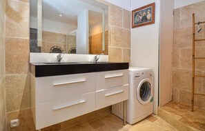 A bathroom with a large mirror, a washing machine, and a towel rack. - Gorgeous home in Comps (Comps)