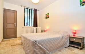 A bedroom with a bed, a nightstand, a radiator, a window with curtains, and a wall-mounted picture. - Gorgeous home in Comps (Comps)