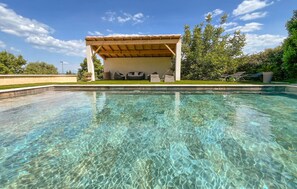 A clear swimming pool with a wooden deck and lounge chairs. - Gorgeous home in Comps (Comps)