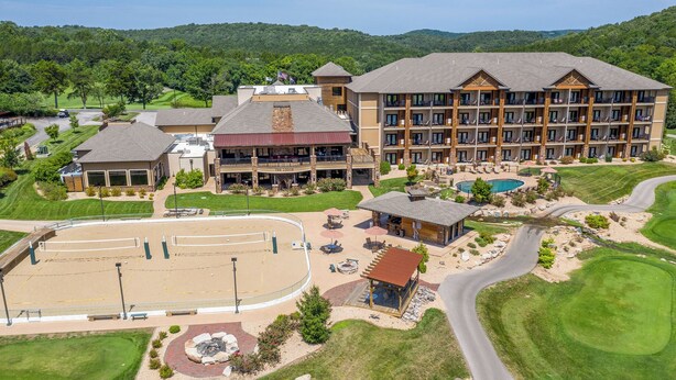 Un resort con varias edificaciones, piscina y campo de golf.