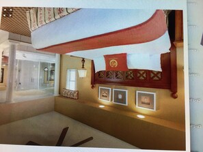 Traditional room with a patterned wall, framed pictures, and a cozy atmosphere.