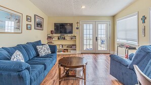 A living room with a blue sofa, a wooden coffee table, and a bookshelf.