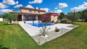 A two-story house with a swimming pool, outdoor seating, and a well-maintained garden. - Villa with swimming pool and table tennis (Divšići)
