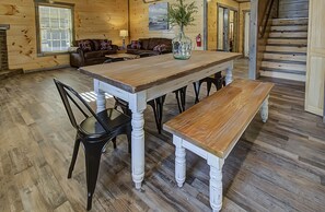 A wooden dining table with benches, a brown leather sofa, and a vase with flowers. - So READY to host you!REDUCED RATES!Close to DW & Cal Ripken Fields! Perfection! (Sevierville)