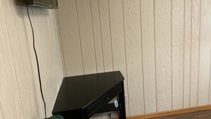 Huone, jossa on musta työpöytä seinää vasten. Seinässä on pystysuorat paneelit.