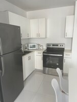 Full-size fridge, microwave, cookware/dishes/utensils