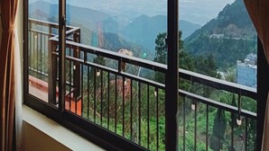 Una stanza con una grande finestra che si affaccia su un paesaggio montuoso.