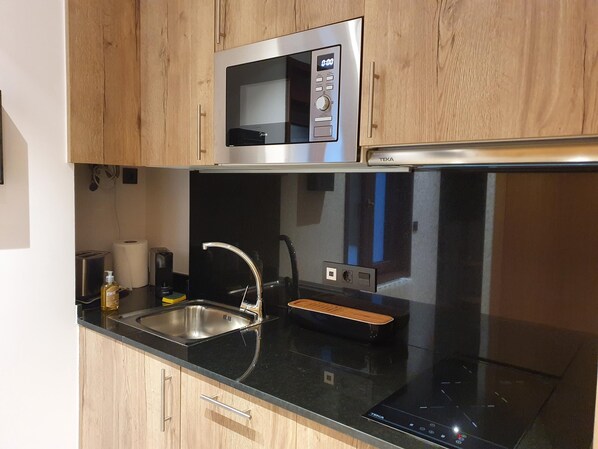 A modern kitchen with a microwave, sink, and built-in oven.