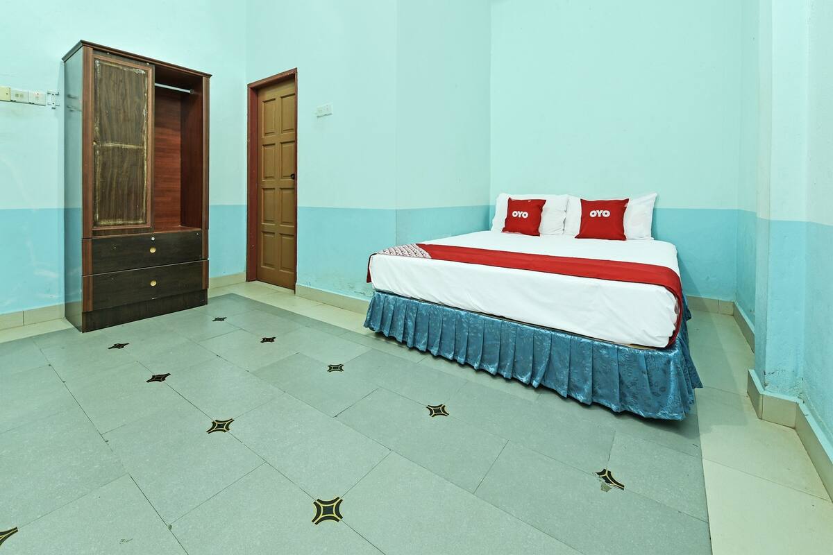 A bedroom with a bed, a wardrobe, and a door.