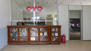 A reception area with a glass display case containing various items, a fire extinguisher, and a door labeled "TARIK".