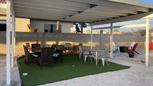 A covered patio area with outdoor furniture, a small artificial grass patch, and a view of the surrounding landscape. - 1 Bedroom 1 Bath Great Location (Las Vegas)