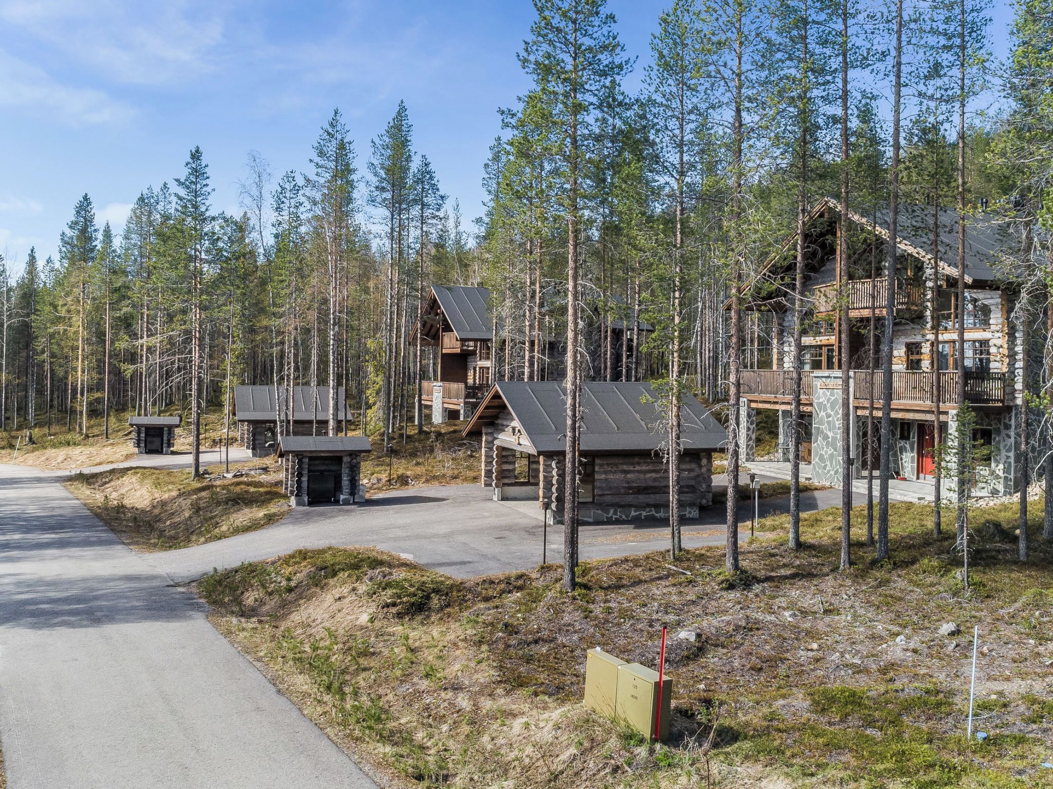 Eine Lodge mit mehreren Hütten, einem Hauptgebäude und einem umgebenden Wald.