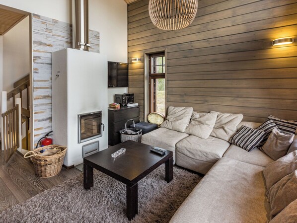 A cozy living room with a fireplace, sofa, and a television.