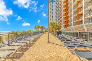 Guests can enjoy ocean views from the sun loungers along the paved walkway.