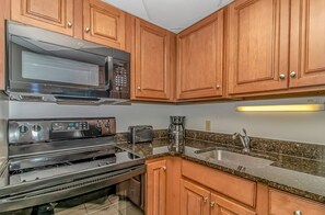 Enjoy cooking in this well-equipped kitchen with a microwave, toaster, coffee maker, and sink.