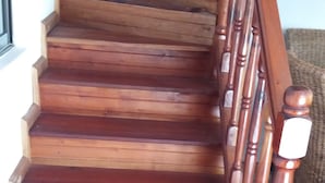 A wooden staircase with a handrail, leading to an upper floor. - Family size of 6 persons,  extra bed upon requestor , Beach front (Anse Boileau)