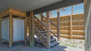 A wooden staircase leading to a covered area with a metal fence in the background. - Spacious 3BR Beach Retreat Sleeps 10 | Family Ready (Port St. Joe)