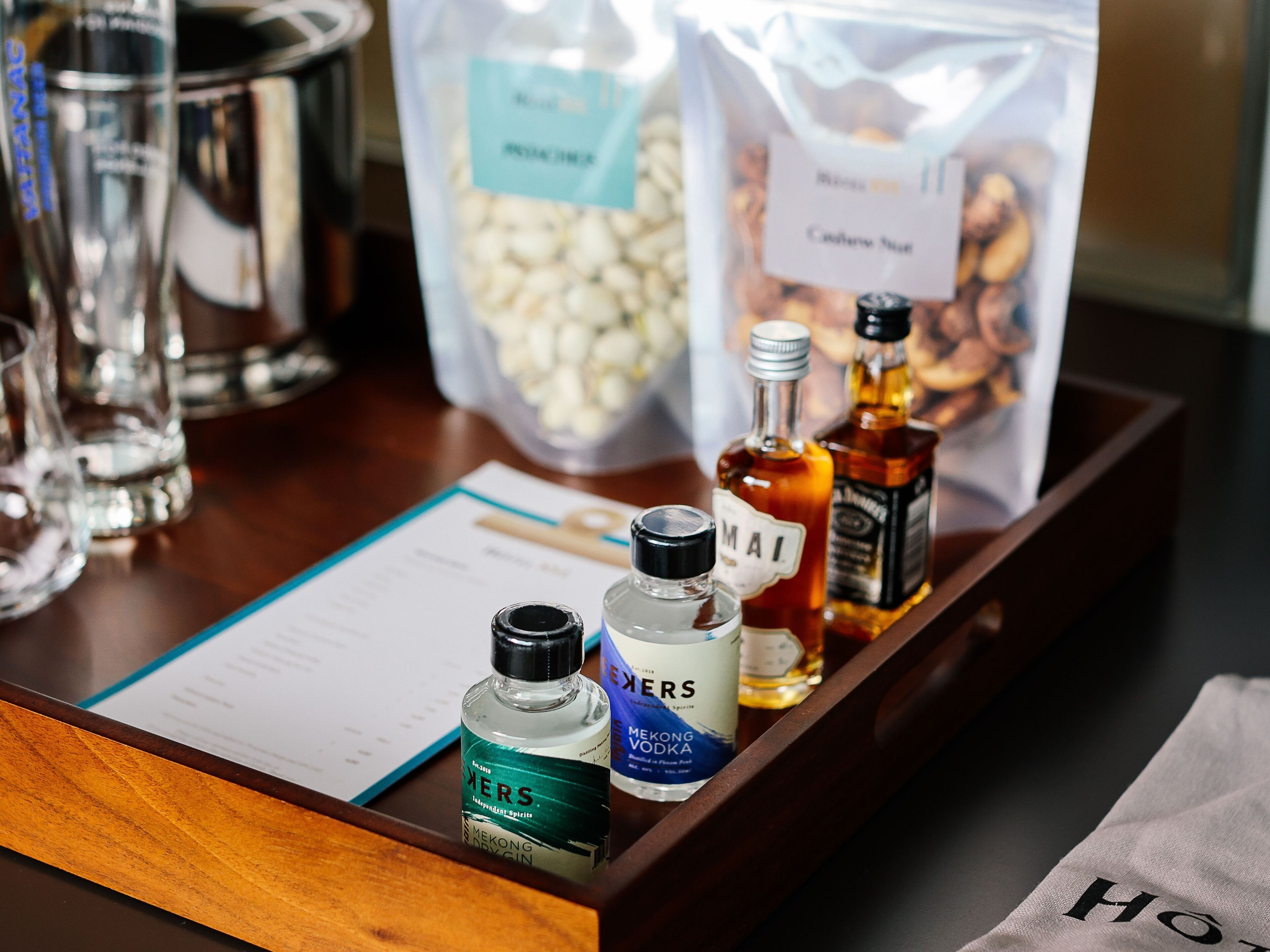 A tray with bottles of alcohol, a bag of popcorn, and a menu.