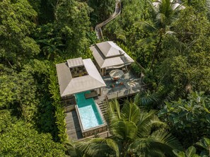 An aerial view of a resort with a pool, outdoor seating, and a staircase leading to the upper level. - KClub Ubud (Tegallalang)